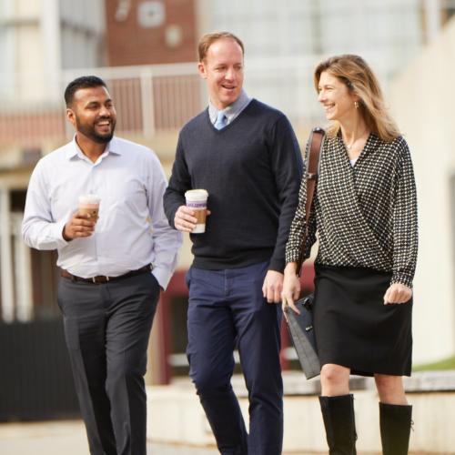 three alumni walking